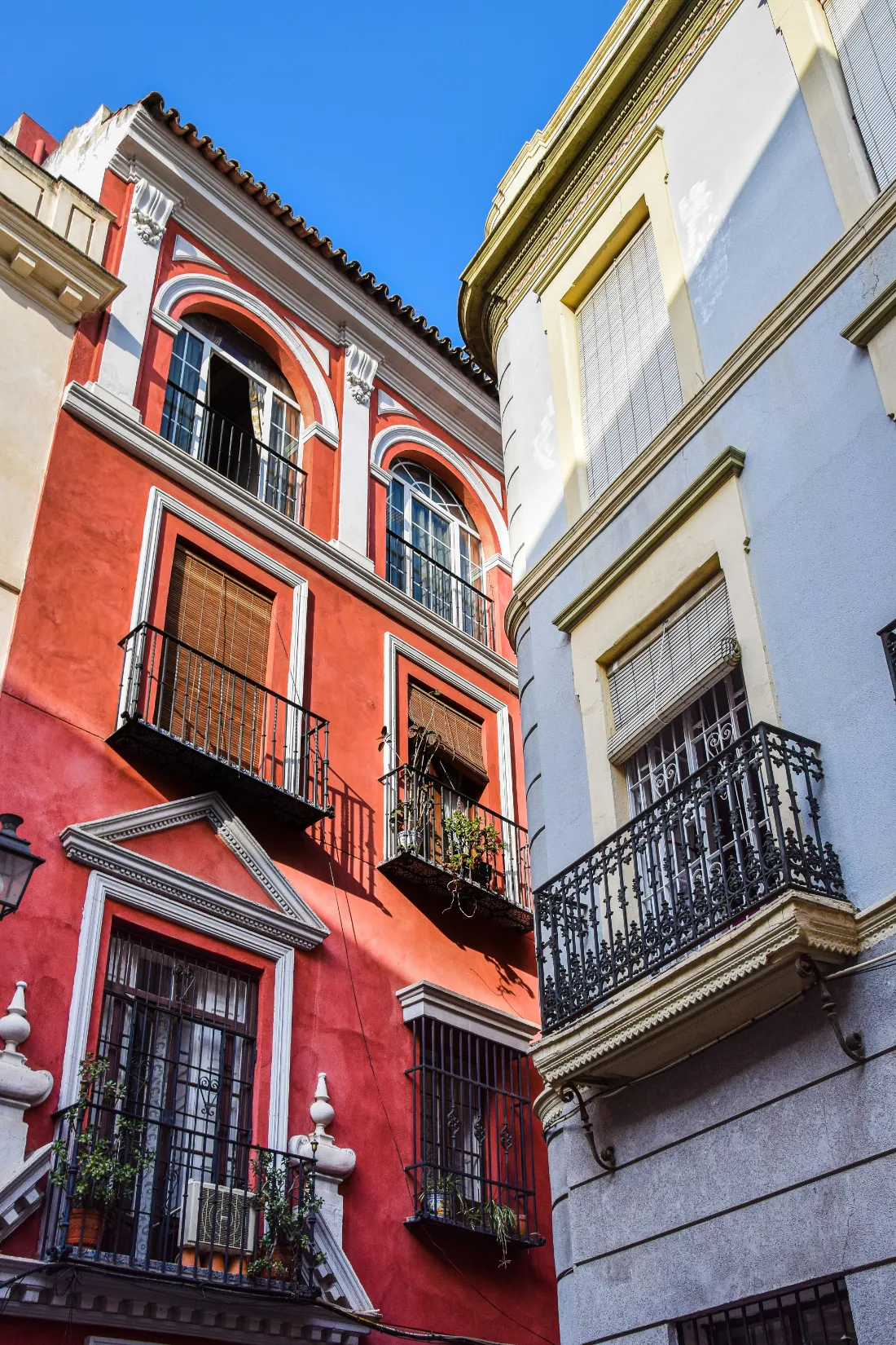 Fachadas rojas y blancas con balcones de forja en un edificio de viviendas