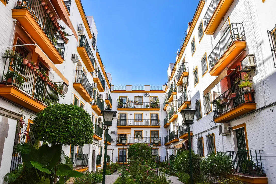 Patio de manzana con edificios blancos de balcones y macetas