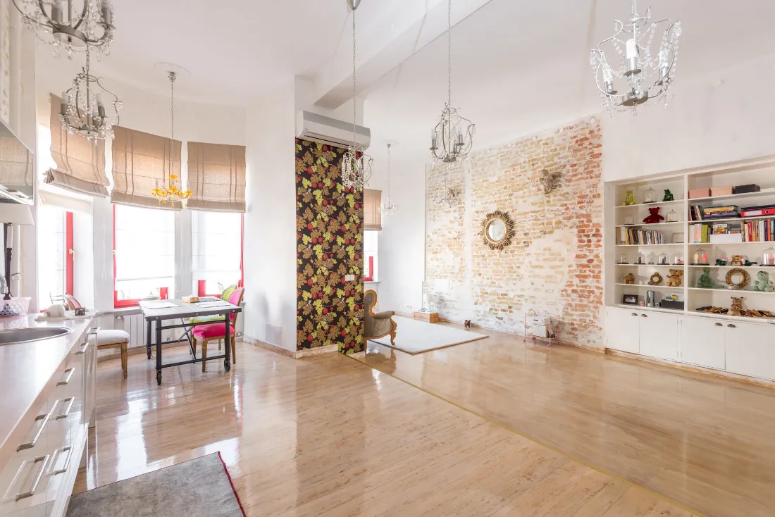 Salón y cocina abiertos, con suelo de madera y mucha luz